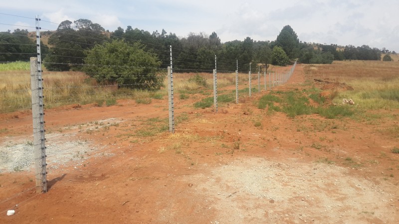 Electric fencing with barbed wire barrier on concrete posts